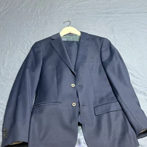 Marinblå dressman kostym - Dressman kostym använd bara en gång, köpte den för ett bröllop men har ingen användning av den längre. Storlek på kavajen är 44 och 29/32 på byxorna. Kan gå ner i pris vid snabb affär  