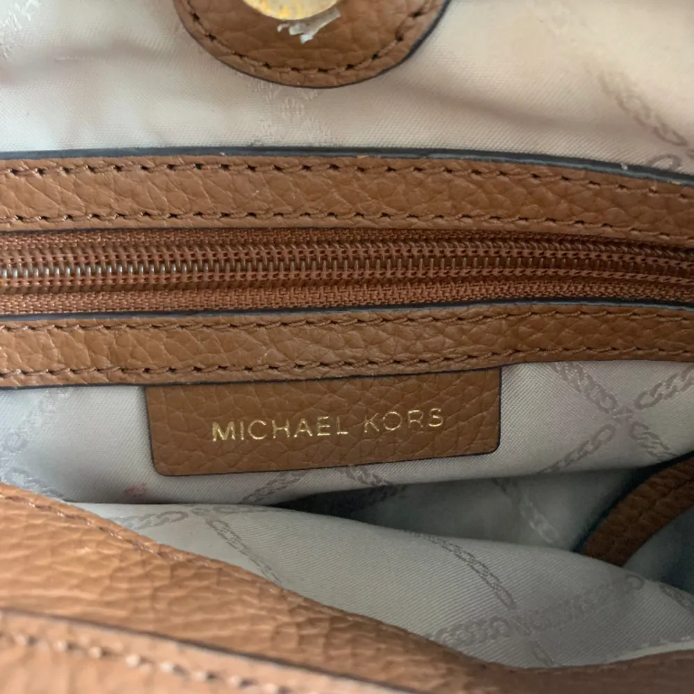 Äkta Michael kors handväska Carrie i färgen Tan, fint skick Ca 17 cm hög o 30 cm bred.. Väskor.