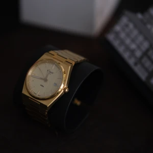 Tissot PRX 40mm Quartz  - En Tissot PRX, 40 mm, guld, quartz ref: T137.410.33.021.00 Sparsamt använd, och i så gott som nyskick. Komplett med box, länkbitar och ett extra band från Tissot i svart krokodil (T852.047.562) Inköpt 2022.