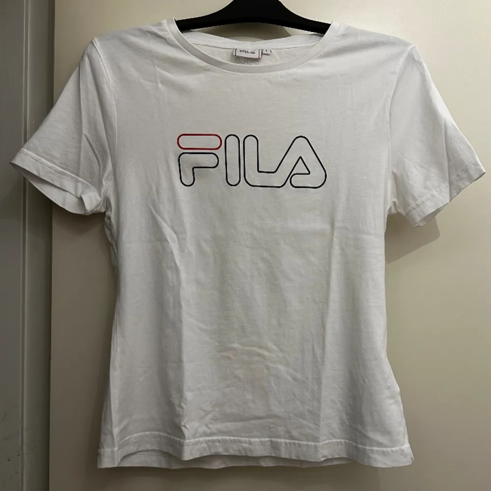 Vit Fila t-shirt i storlek L, men mer som en storlek M. Aldrig använd.. T-shirts.