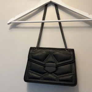 Väska - Svart väska med långt band som går att han crossbody men även över axeln. 