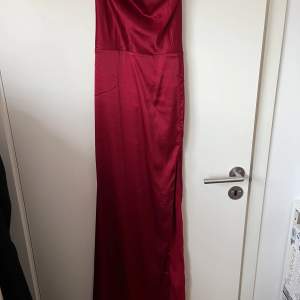 Vinröd långklänning i satin. Använd 1 gång storlek 38. Sitter jättefint på. Köparen står för frakten. Org pris 699kr säljer för 250kr