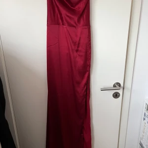 Röd långklänning - Vinröd långklänning i satin. Använd 1 gång storlek 38. Sitter jättefint på. Köparen står för frakten. Org pris 699kr säljer för 250kr