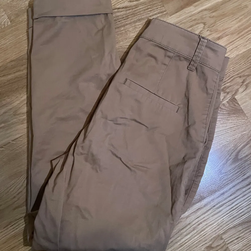 Kostymbyxor (straight leg). Mörk beige färg. Storlek finns på bild 4. Bra material och kvalite. Nyskick. Medelhögmidjade. Kan postas, isf står köpare för frakt. Annars funkar upphämtning i Malmö. . Farkut & Housut.