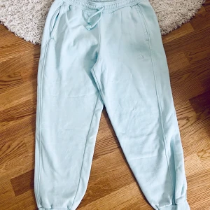 Adidas mjukisbyxor, L - Ljusblåa Adidas mjukisbyxor i fint skick. Storlek L, loose fit. Nypris 699kr.