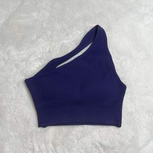 Marinblå one shoulder sport-bh i modellen ”GLAM” från www.astaniwear.com Oanvänd, saknar logga Strl: XS