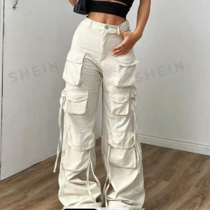 Ljus Beiga Cargo Byxor - Ett par ljusa byxor som vara provats på en gång, på bilden ser byxorna vita ut men i verkligheten är dom lite mer vit/beige. Byxorna är väldigt tunna och skulle rekommendera till sommaren.