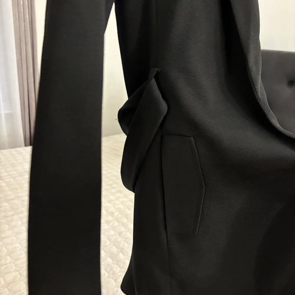 En svart kappa från Only i storlek xs, har fickor i båda sidorna, den är i knälängd! Med snöre runt om man kan knyta hur man vill. Jackor.