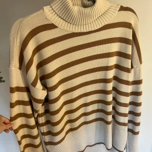 Randig stickad tröja - Randig brun beige stickad tröja med polo, använd fåtal gånger men i nyskick. Vid fler frågor eller bilder är det bara att kontakta i chatten, Köparen står för frakten💕