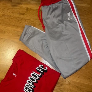 Liverpool kläder  - Tracksuit byxor i storlek XL och tisha i storlek XL. Helt nytt men prislapparna är borta pga att det var en present men blev tyvärr för litet.  