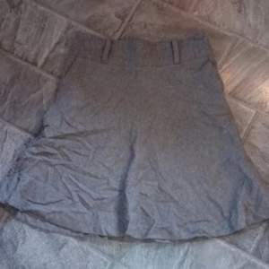 Grå fodrad kjol i ull från H&M i storlek 40. Knälång.  65 cm lång.  Väldigt fint skick. 