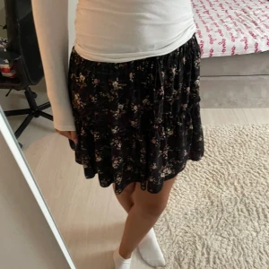 Kjol - En svart kort kjol med blommigt mönster på! Lite tight högst upp men inget som stör en!❤️