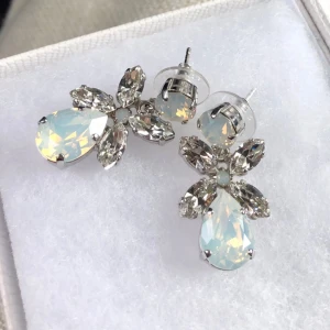 Caroline Svedbom Dione örhängen  - Jätte fina och endas använda vid ett tillfälle  Silverfärgade med rhodium plätering och Swarovski kristaller i unik färg 