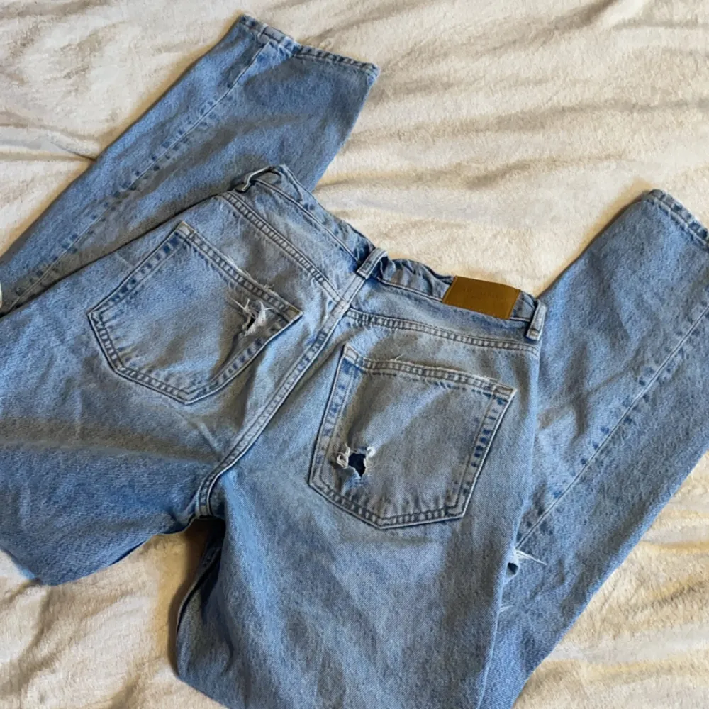 Högmidajde jeans med hål från Gina Tricot. Fint skick men hålen är lite uttöjda . Jeans & Byxor.