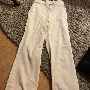 Vita kostym byxor - Säljer mina vita utsvängda kostymbyxor då dem inte kommer till användning längre. Är i bra skick och knappt använda.