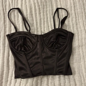 Korsett topp - Mörkbrun korsett topp från HM. Köpt här på Plick för något år sedan och har endast använts 3 gånger av mig. Dock har en söm gått upp vid banden och säljes därför billigt ♥️