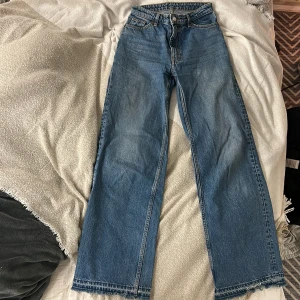 Monki Vida blå Jeans - Ett par vida blå jeans från Monki i stl.25. Jag har spretat upp längst ner på byxorna så de är lite längre, där de också är lite slitna. Lite slitet i ena fickan pga mobilen. Säljer då de inte längre används🩷