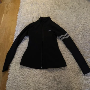 Stronger träningsjacka - Säljer denna träningsjacka från stronger i storlek XS som är i bra skick förutom att dragkedjan tyvärr inte går att stänga på grund av att en del har lossnat (se bild 3). Sparsamt använd. Säljer den billigt på grund av dragkedjan. Nypris: 700 kr.
