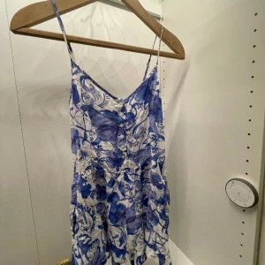 Jumpsuit - En blå vit jumpsuit med korta ben som er ut en klänning, sjukt skön att ta till stranden osv. Hör av er om ni har frågor eller vill ha bilder när det sitter på🤗 Bandet som hänger runt galjen kan man knyta runt midjan om man vill😃
