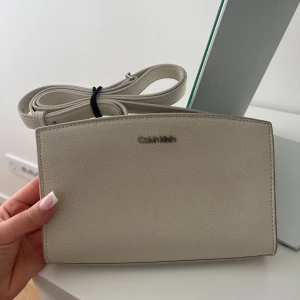 Calvin klein axelremsväska  - Calvin klein axelremsväska från Zalando. Helt nytt skick. Perfekt storlek och fina detaljer. Nypris 1200kr. 
