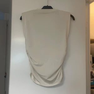 Toppar - Toppar från H&M i beige och svart. Använda 1 gång. Säljer pga de ej används längre. Köpte båda för 150kr styck. Säljer en för 60kr och båda för 100kr. Den beiga har en liten smink fläck (sista bild) men den syns ej mycket. Går säkert att ta bort.