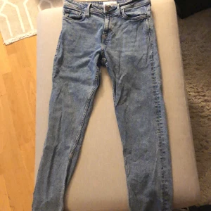 Blå jeans från Stock & Hank - Ett par blå jeans från Stock & Hank. Jeansen har en klassisk design med fem fickor och en knappgylf. De är tillverkade i ett slitstarkt denimtyg.
