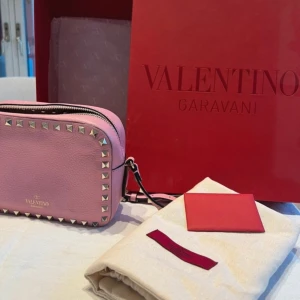 Rosa valentinoväska camerabag - Jättefin ljusrosa valentino camera bag med guldiga nitar. Nästan oanvänd i fint skick. Inga defekter eller likande. Skickar gärna fler bilder om det behövs 💞💞 priset kan diskuteras!!