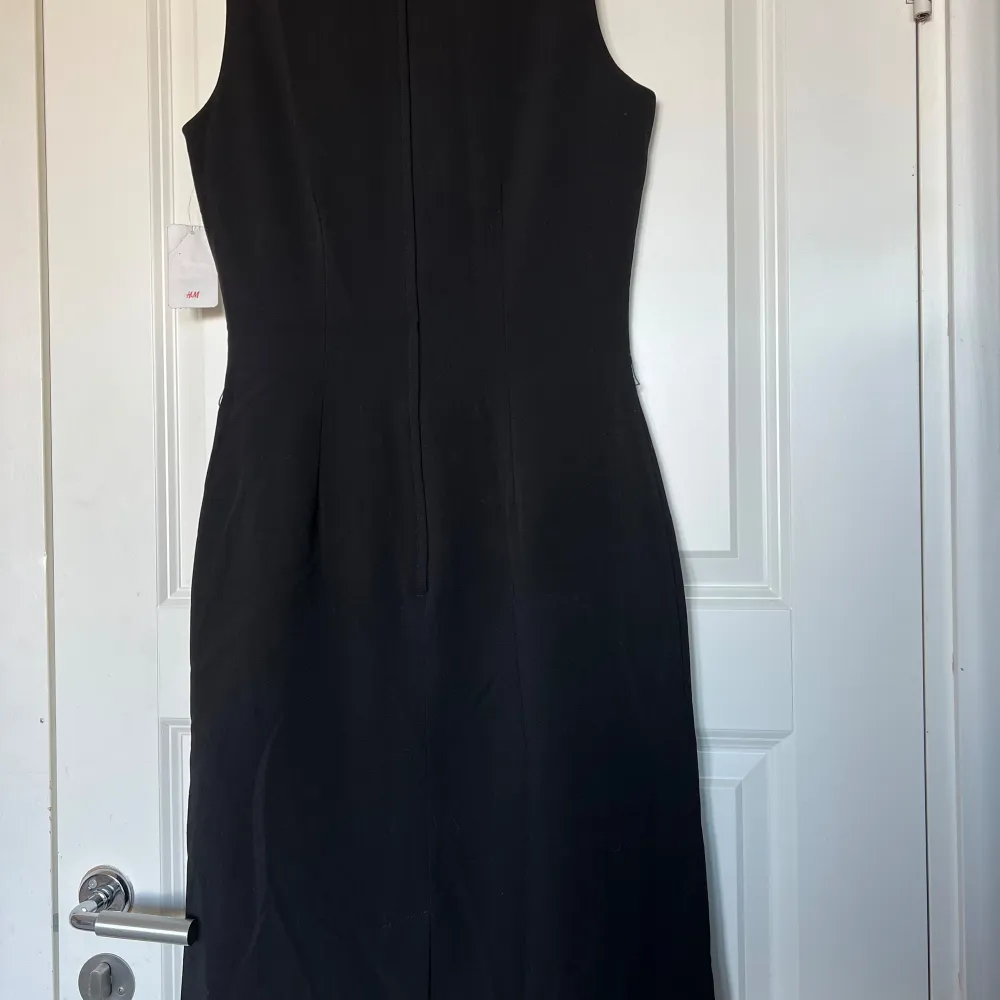 Fin klassisk svart klänning från H&M. I nyskick, med prislapp kvar. Underklänning inuti. Dold dragkedja baktill. Storlek 34. Originalpris: 298kr. Upphämtning i Malmö möjligt.. Mekot.
