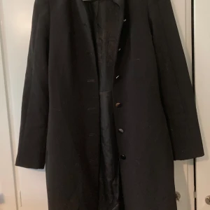 Kappa - Figursydd kappa med små axelvaddar.