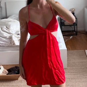 Röd satinklänning - Superfin röd satinklänning från Zara med öppen rygg och cut outs. Storlek L men skulle säga att den är liten i storleken och mer som en M.