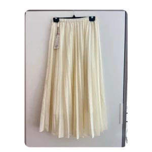 Plisserad kjol - Helt ny Plisserad kjol i krämvit färg i storlek S. Defekt förekommer. Se bilden 
