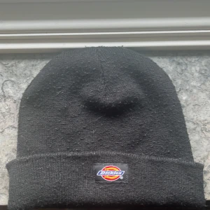 Äkta Dickies mössa - Äkta Dickies mössa. Lappen har några skador men Annas har mössan inga andr skador. Mössan är också tjock. 