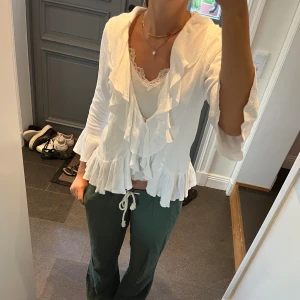 Vit stickad kofta med volanger  - Stickad kofta från Lindex i storlek M. Fint skick. Använd gärna köp nu!