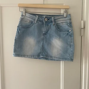 Kort Lågmidjad jeanskjol - Säljer en kort, Lågmidjad jeanskjol. Säljer då den är lite för liten för mig. Är storlek 36 men passar även 38. 