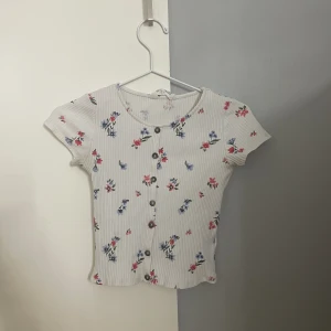 Två kortärmade tröjor - Jag säljer TVÅ TRÖJOR för 90 kr.   Den vite tröjan är från H&M och jag tror att den blåa tröjan också är det. Jag vet inte eftersom lapparna är bortklippta. Därför vet jag inte heller vilken storlek den är men jag tror att det är 146/152 som den vita