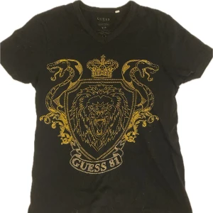 Guess tröja - Säljer denna snygga guess tröjan med guld detaljer🖤💛 jättebra skick! passar mig perfekt som brukar ha M. 