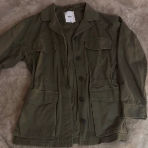 mörkgrön jacka - jacka ifrån Dobber, använd en gång. går att dra in i midjan så man får mer form på jackan