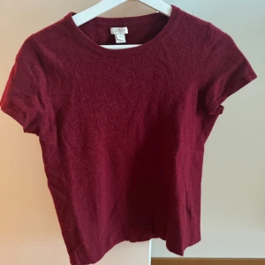 Kortärmad stickad tröja  - Snygg vinröd stickad tröja! I storlek M men är liten i storlek så skulle säga passar mer XS/S. Knappt använd så i bra skick!