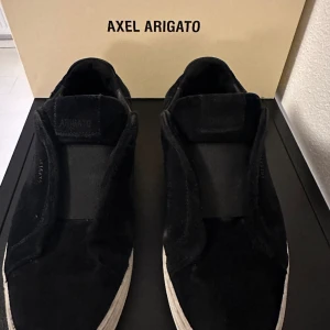 Axel Arigato laceless  - tja, säljer ett par sköna svarta  arigatos laceless i mocka som är i 8/10 i skick, säljer dom nu för dom blivit försmå. Passar dig som har mellan 41-42 i storlek!! Box och dustbag med följer i köpet!  hör av dig vid fler bilder och frågor!!🙌🏽🤝🏽