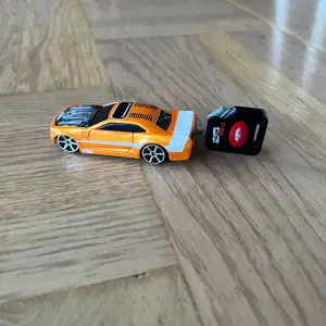 Orange leksaksbil som skjuts iväg när man trycker på nyckeln 
