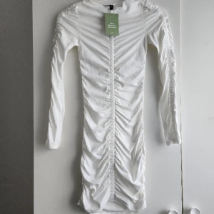 Vit klänning  - Säljer denna tjusiga vita klänningen från H&M som aldrig kom till användning. Materialet är jätteskönt. Passar S/XS. Original pris är 199kr säljer för 70kr. Passa på 😉.