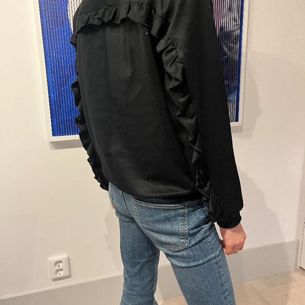 En svart MOLO tröja med volanger i storlek 176  Extremt skön och har nästan ett lite mitalligt utseende🖤💕💕 Pris kan diskuteras 👍👍. Tröjor & Koftor.