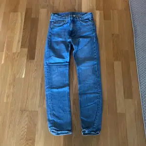 Ett par blå jeans från Weekday i storlek W28 L32. Modellen är Easy Regular Straight Jeans.