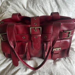 Vintage vinröd väska från år 1986🩷🫣 - Väskan är knappt använd av mig men jag köpte den vintage själv!! Den är perfekt nu till hösten, den vinröda färgen är en underbar🙌🏼🍂 defekten på väskan är ena fickan där stygnen har gått upp! Men det syns inte om man stänger fickan med låset🥲🙏🏼