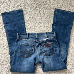 Lågmidjade Bootcut jeans Wrangler  - Lågmidjade jeans från Wrangler, storlek w26 L30. Passar alltså någon som inte är så lång. Innerbenslängd:75 midjemått:36x2 sträcker sig till 40. Köp sker via köp nu, postar inom 24h. Kvar tills markerad såld ❗️❗️
