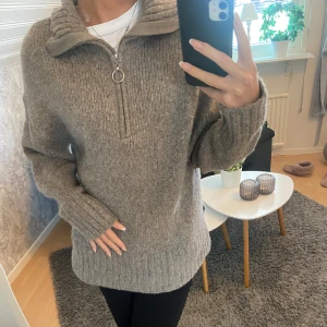 Brum stickad tröja  - En jättefin och mysig brun/grå stickad tröja i jättebra skick. Har även en dragkedja så man kan få en krage på tröjan. Det går även att knipsa bort ”ringen” på dragkedjan ifall man inte vill ha den🩷🩷