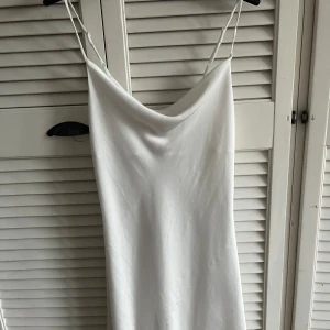 Vit slip on klänning - Klänningen är köpt på Gina Tricot och endast använd fåtal gånger, inte trasig någonstans och i mycket gott skick. Klänningen är i storlek 34 och skulle säga att den passar både de som har XS och S.