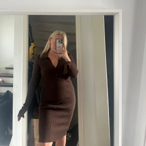 Ribbstickad klänning  - Ribbstickad klänning från Gina tricot.  Fina detaljer med knapparna framtid och slits på armarna.  