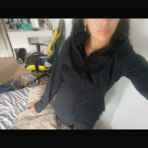 Svart skjorta  - En svart skjorta som är helt ny, den är kroppsformernas och sitter relativt tight på kroppen 