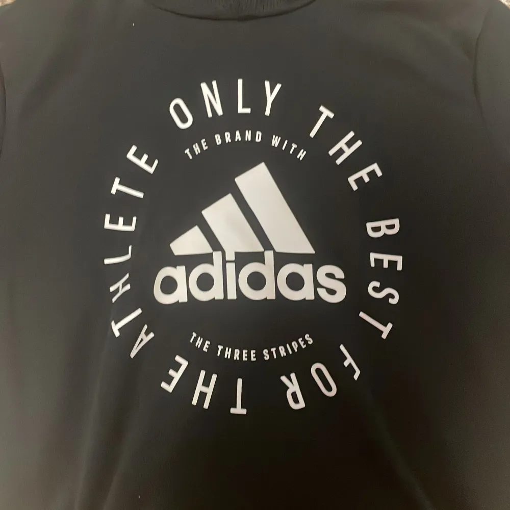 Tja säljer en svart Adidas hoodie med text på framsidan. Storlek 152. Använd ett par gånger men fortfarande väldigt bra skick. Hör av er vid frågor!. Hoodies.